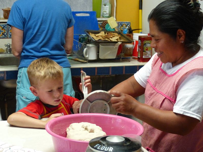 Teresa helps Quinn press the masa dough for the moletos