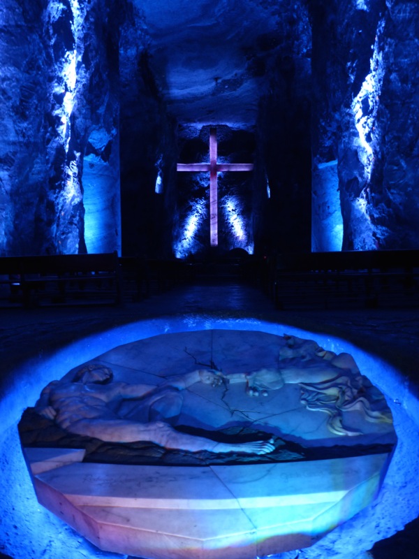 The cross in the background is 170 feet high. This was just one of numerous crosses and religious carvings in the mine.