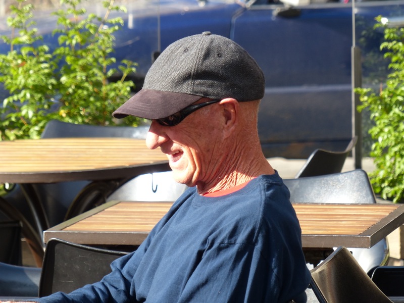 Papa enjoys a sunny morning at a coffee shop.